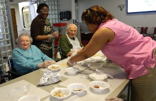 Speech therapist Shayla Oaks-Rester looks on as activities coordinator Anita Payne sets out ingredients for residents Doris Gingrich and Harold Hixon